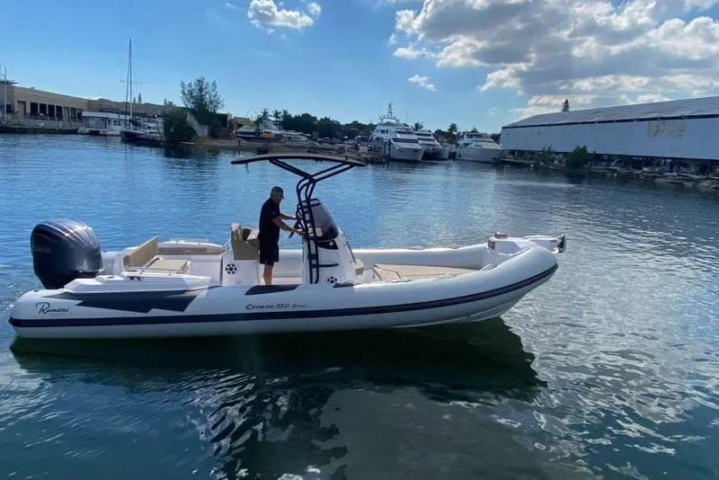 Slide: The Image of 2026 Ranieri CAYMAN 23 Sport boat on calm water, clear sky, marina background. - 3