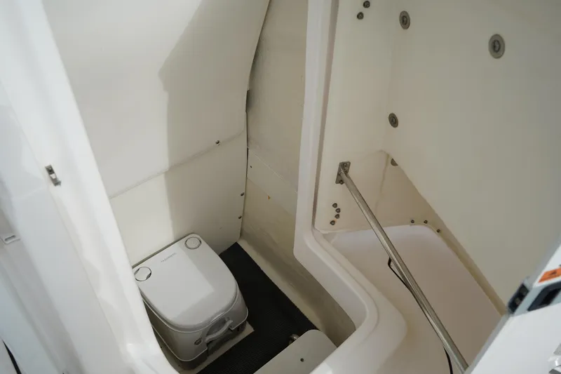 Slide: The Image of 2023 Robalo R222 Center Console boat interior with compact marine toilet. - 21