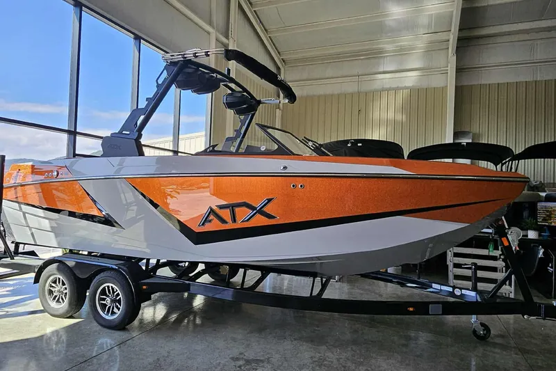 Slide: The Image of 2026 ATX Surf Boats 22 Type-S in showroom, orange and white design, on trailer. - 11