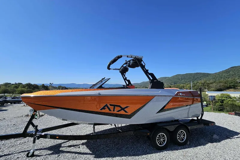 Slide: The Image of 2026 ATX Surf Boats 22 Type-S in vibrant orange, parked on a trailer, mountain backdrop. - 17