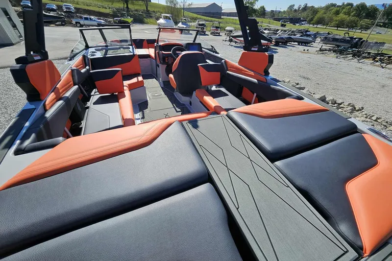 Slide: The Image of 2026 ATX Surf Boats 22 Type-S interior with orange and black seating, parked outdoors. - 21