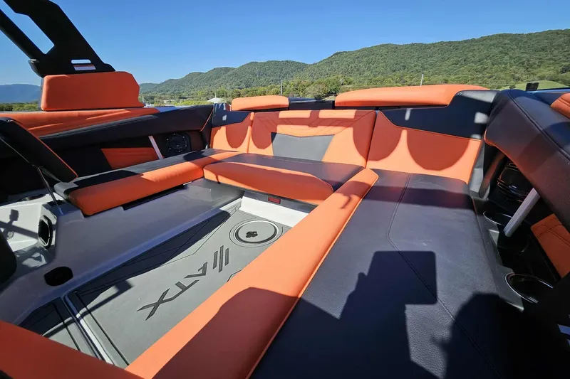 Slide: The Image of 2026 ATX Surf Boats 22 Type-S interior with orange and black seating, scenic mountain backdrop. - 22