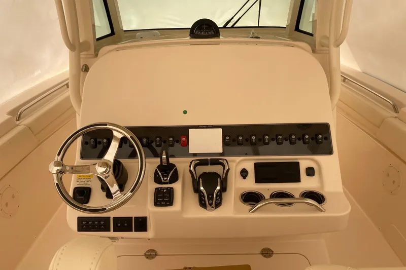 Slide: The Image of 2026 Grady-White Canyon 306 helm with steering wheel and control panel. - 10