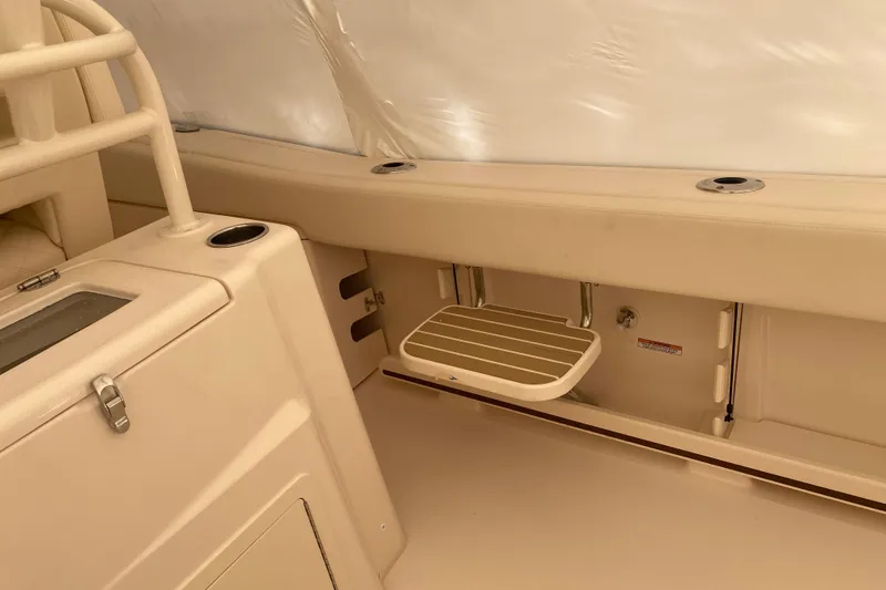 Slide: The Image of 2026 Grady-White Canyon 306 boat interior with beige seating and storage features. - 12