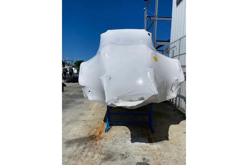 Slide: The Image of 2026 Grady-White Canyon 306 boat wrapped in protective covering, outdoor storage. - 17