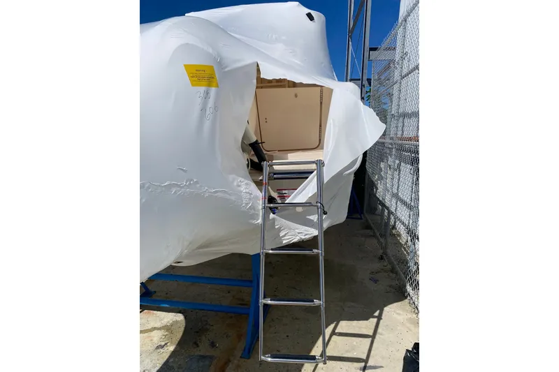 Slide: The Image of 2026 Grady-White Canyon 306 boat partially covered, with ladder access. - 18