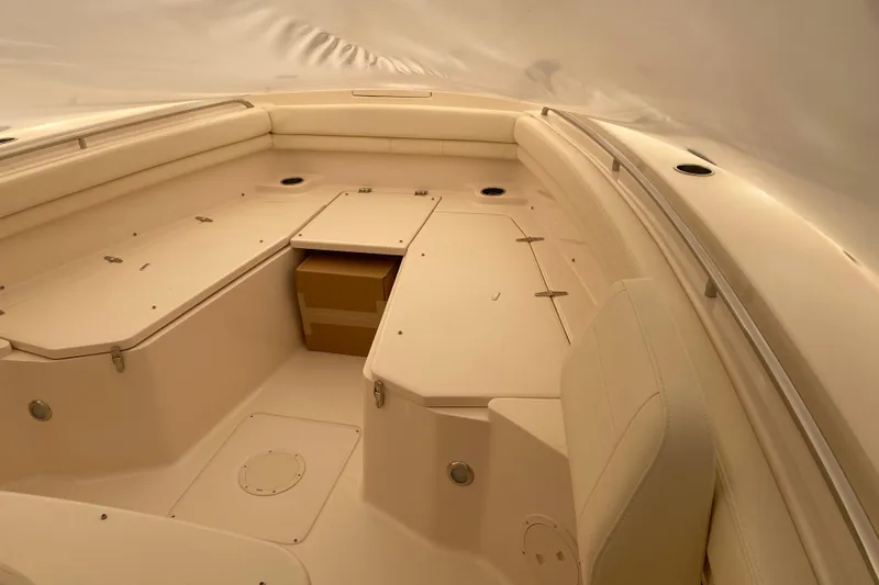 Slide: The Image of 2026 Grady-White Canyon 306 boat interior with beige seating and storage compartments. - 2