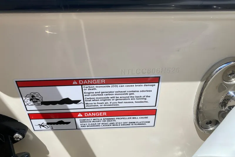 Slide: The Image of Warning labels on 2026 Grady-White Canyon 306 boat, highlighting carbon monoxide and propeller dangers. - 21