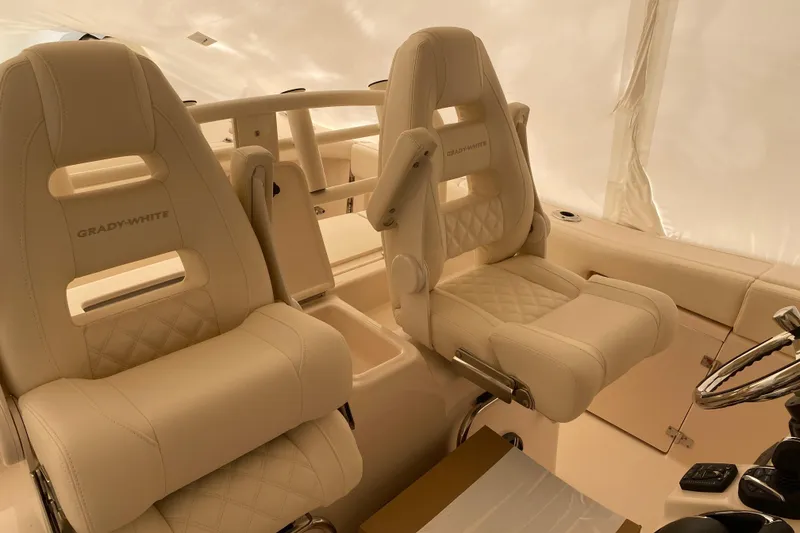 Slide: The Image of 2026 Grady-White Canyon 306 boat interior with luxurious beige seating and steering wheel. - 9