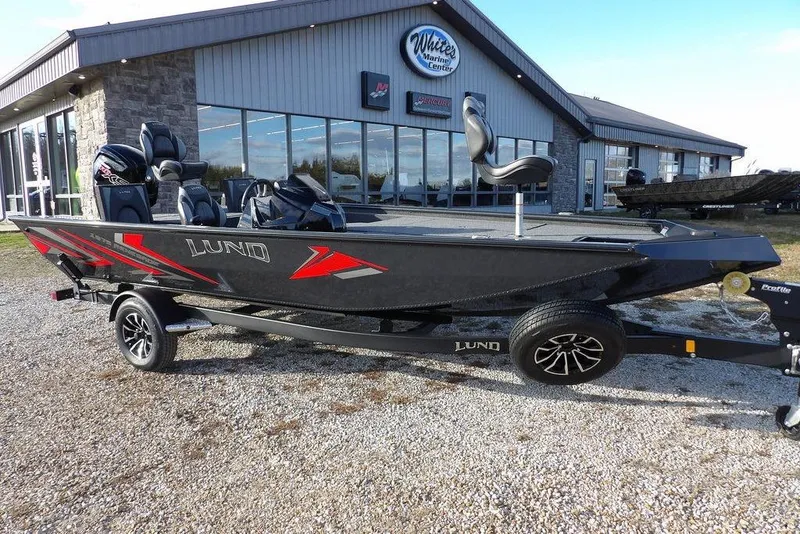 The Image of 2026 Lund 1875 Renegade boat on trailer outside marine center. - 1