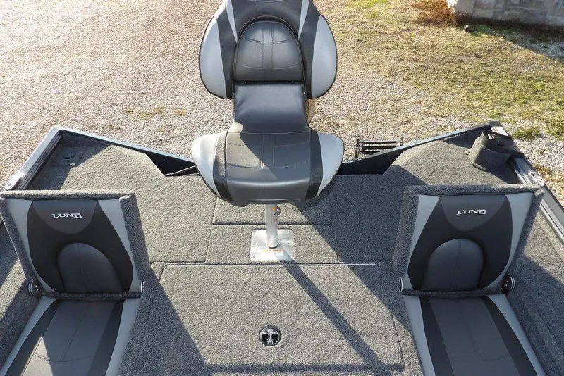 Slide: The Image of 2026 Lund 1875 Renegade boat interior with three gray seats on carpeted deck. - 12