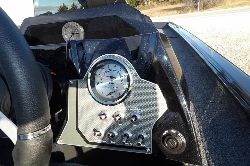 Slide: The Image of 2026 Lund 1875 Renegade boat dashboard with RPM gauge and control switches. - 22