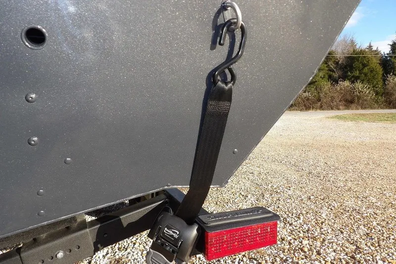 Slide: The Image of 2026 Lund 1875 Renegade boat trailer with secure strap and red reflector. - 47