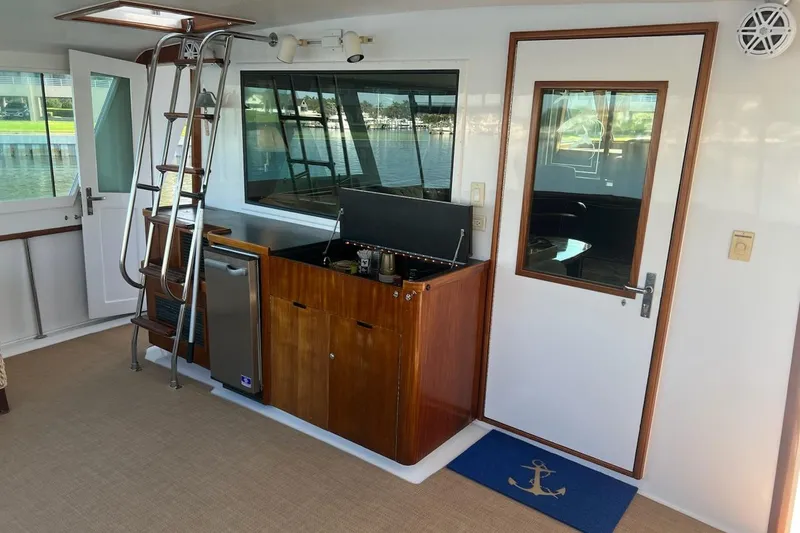 Slide: The Image of 1985 Hatteras 58 Motor Yacht interior with ladder, wooden cabinetry, and nautical decor. - 17