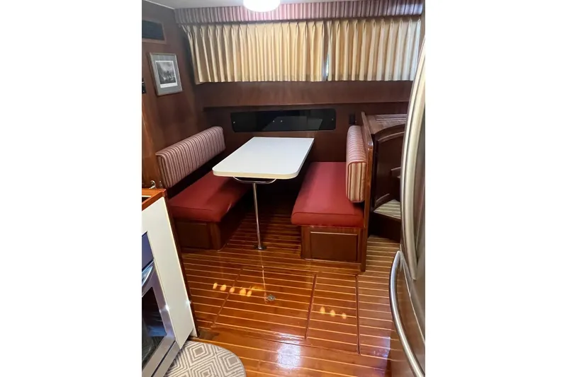 Slide: The Image of 1985 Hatteras 58 Motor Yacht interior with dining booth and wooden flooring. - 24