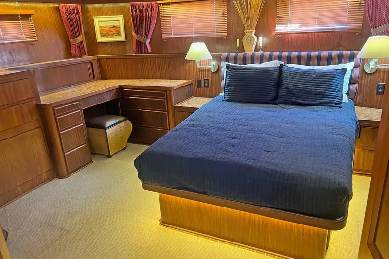 Slide: The Image of Luxurious bedroom interior of 1985 Hatteras 58 Motor Yacht with wood furnishings and cozy lighting. - 25