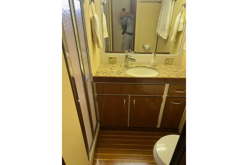 Slide: The Image of Bathroom interior of 1985 Hatteras 58 Motor Yacht with wood cabinetry and granite countertop. - 28