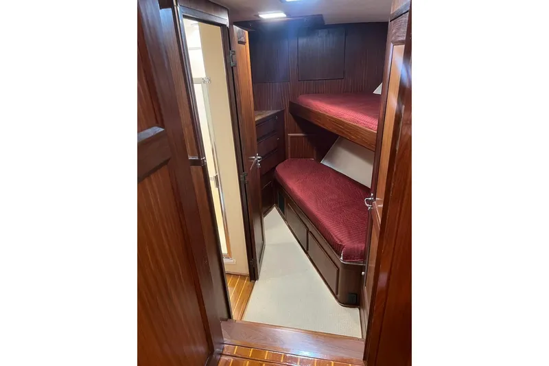 Slide: The Image of Interior of 1985 Hatteras 58 Motor Yacht with wooden bunk beds and red bedding. - 32