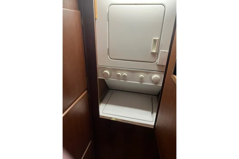 Slide: The Image of Laundry area inside 1985 Hatteras 58 Motor Yacht with stacked washer and dryer. - 33
