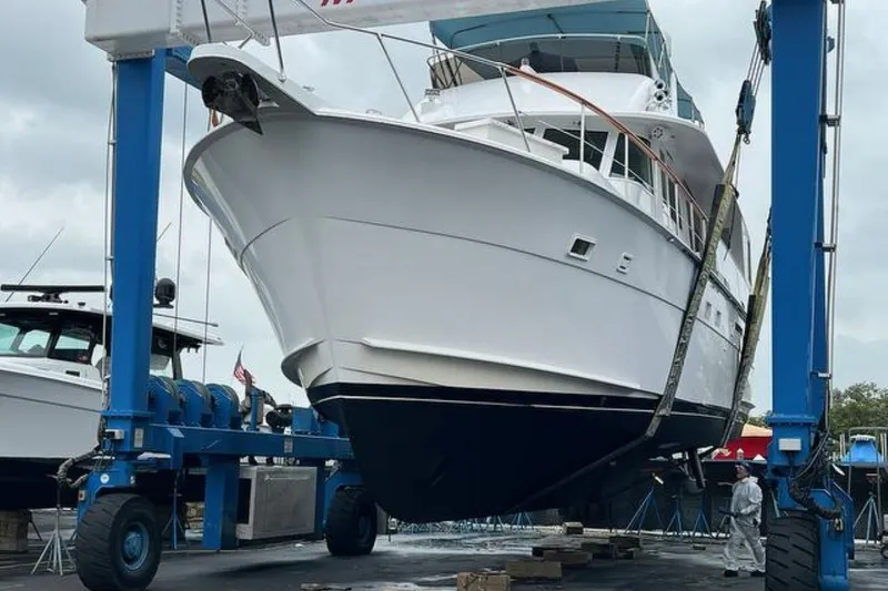 Slide: The Image of 1985 Hatteras 58 Motor Yacht in dry dock, supported by a blue boat lift. - 49