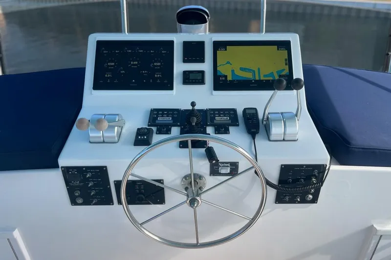Slide: The Image of 1985 Hatteras 58 Motor Yacht helm with navigation screens and controls. - 6
