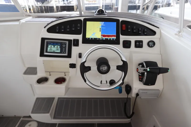 Slide: The Image of Control panel of a 2014 Intermarine 380 Sport boat with navigation screens and steering wheel. - 19