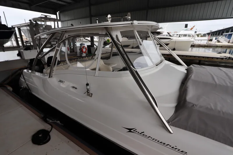 Slide: The Image of 2014 Intermarine 380 Sport boat docked in a marina under a covered shelter. - 8