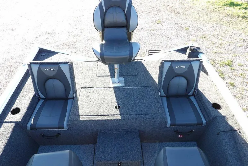 Slide: The Image of 2026 Lund 1975 Renegade boat interior with three gray seats on a sunny day. - 20