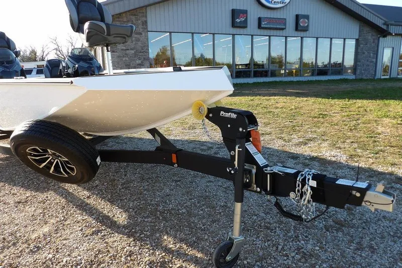 Slide: The Image of 2026 Lund 1975 Renegade boat on trailer outside dealership, showcasing modern design and features. - 44