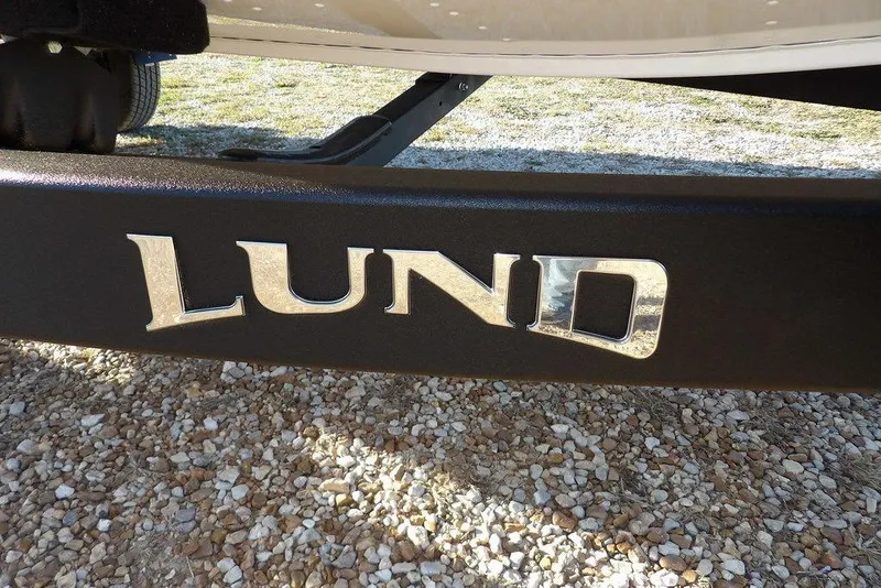 Slide: The Image of Close-up of Lund logo on 2026 Renegade boat trailer, gravel background. - 46