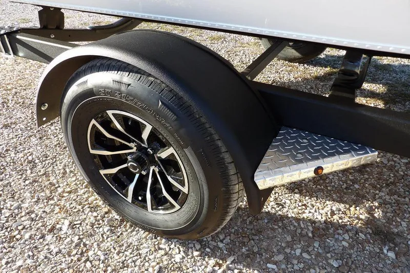Slide: The Image of 2026 Lund 1975 Renegade trailer wheel with black alloy rim on gravel. - 47