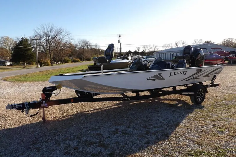 Slide: The Image of 2026 Lund 1975 Renegade boat on trailer, parked outdoors on gravel. - 5