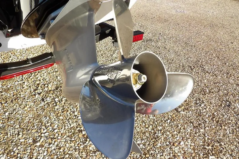 Slide: The Image of Close-up of a 2026 Lund 1975 Renegade boat propeller on gravel surface. - 52