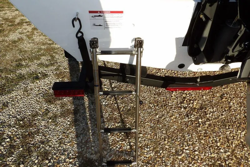 Slide: The Image of Rear view of 2026 Lund 1975 Renegade boat with ladder on gravel surface. - 55