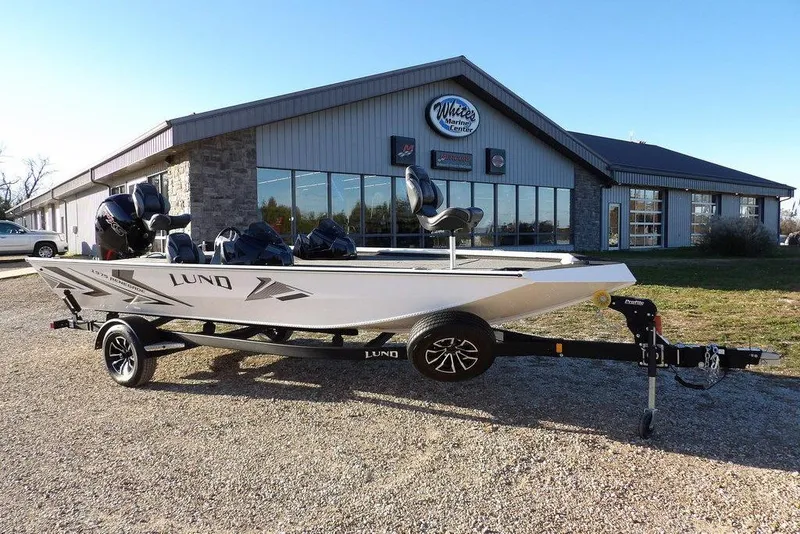 Slide: The Image of 2026 Lund 1975 Renegade boat on trailer outside marine center. - 6