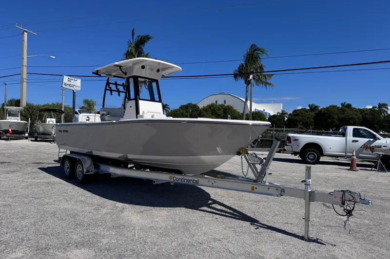 The Image of 2026 Sea Born LX24 Center Console boat on trailer, parked outdoors under clear blue sky. - 0