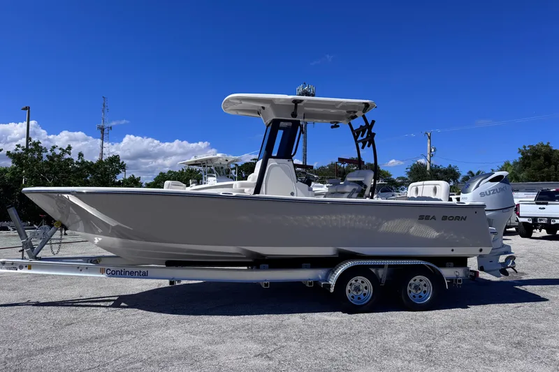 Slide: The Image of 2026 Sea Born LX24 Center Console boat on trailer under clear blue sky. - 2
