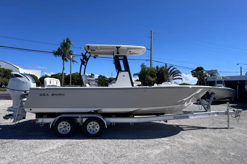 Slide: The Image of 2026 Sea Born LX24 Center Console boat on trailer, parked outdoors under clear blue sky. - 6