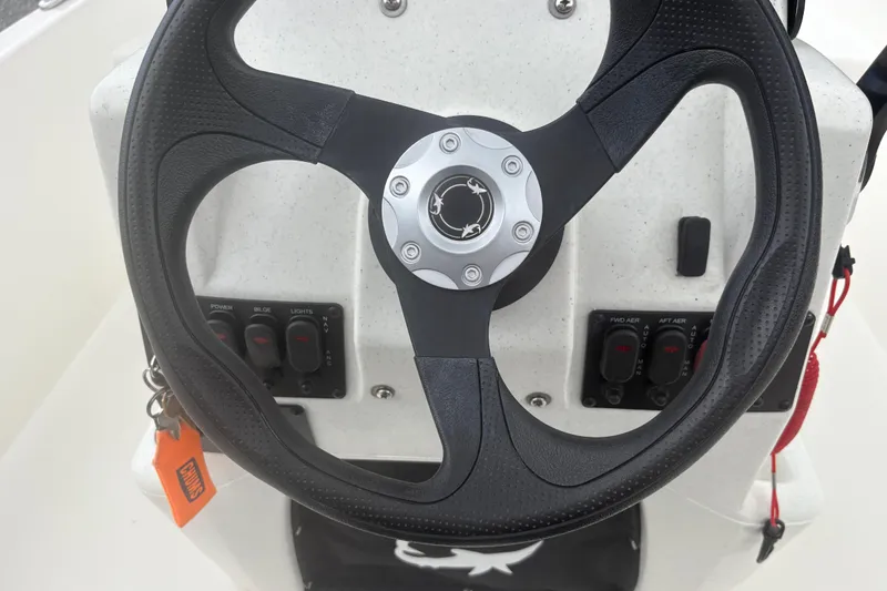 Slide: The Image of Steering wheel of 2023 Mako Pro Skiff 17 CC boat with control panel. - 13