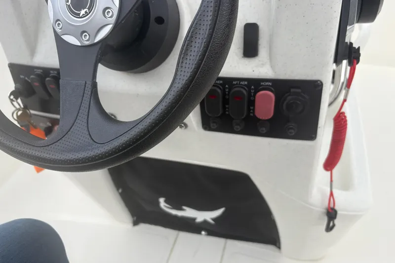 Slide: The Image of Steering console of 2023 Mako Pro Skiff 17 CC with control panel and safety lanyard. - 15