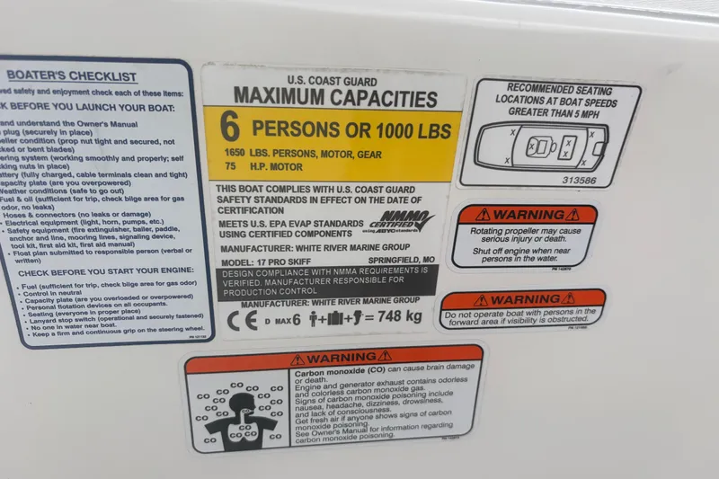 Slide: The Image of Capacity and safety labels on 2023 Mako Pro Skiff 17 CC boat, highlighting weight limits and warnings. - 17