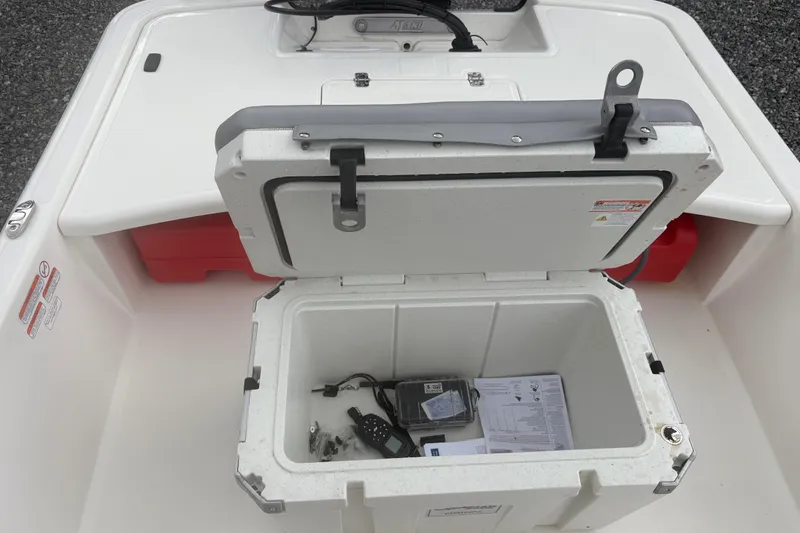 Slide: The Image of Open storage compartment on 2023 Mako Pro Skiff 17 CC boat, showing contents and accessories. - 20