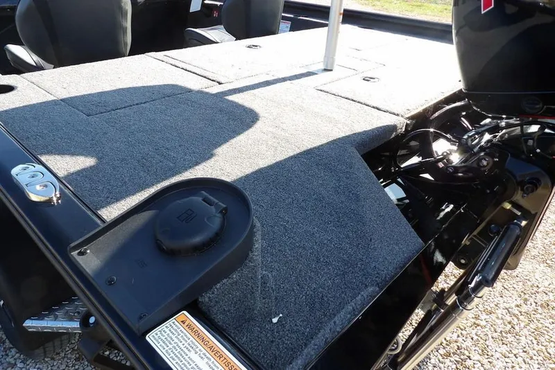 Slide: The Image of 2026 Lund 1975 Renegade boat interior with carpeted deck and motor components. - 11