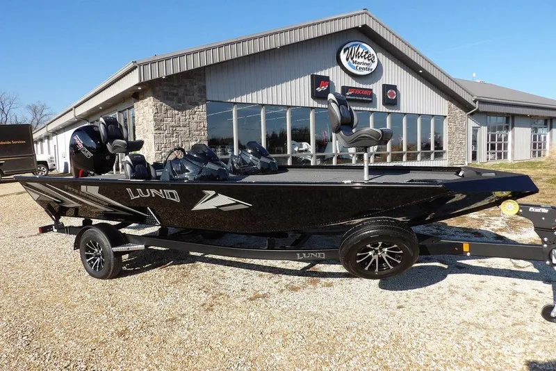 Slide: The Image of 2026 Lund 1975 Renegade boat on trailer outside marine center. - 2