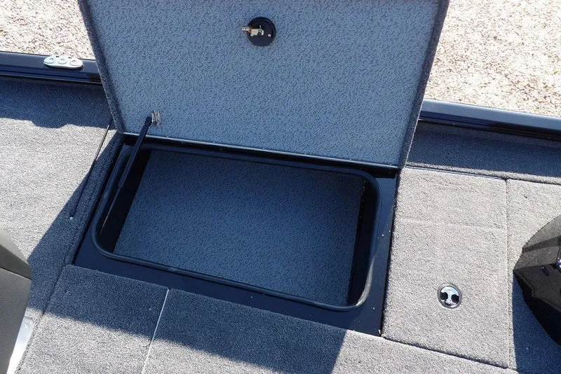 Slide: The Image of Open storage compartment in 2026 Lund 1975 Renegade boat, featuring gray carpeted interior. - 30