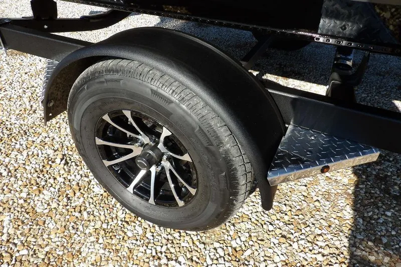 Slide: The Image of Trailer wheel of 2026 Lund 1975 Renegade on gravel surface. - 37