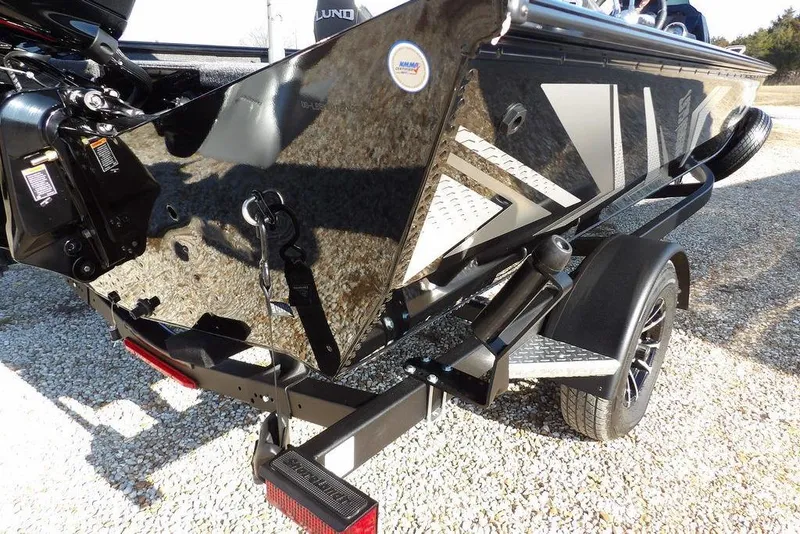 Slide: The Image of 2026 Lund 1975 Renegade boat on trailer, featuring sleek black and silver design. - 38