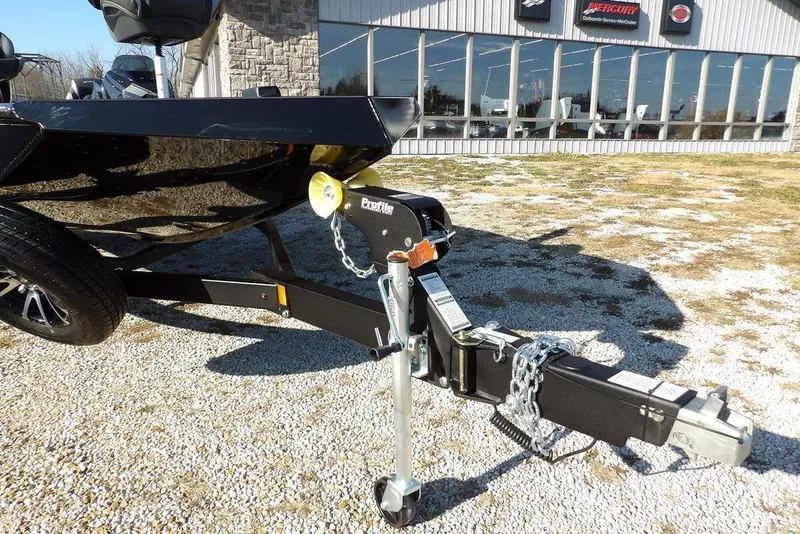 Slide: The Image of Trailer hitch of 2026 Lund 1975 Renegade boat, parked on gravel near a showroom. - 40