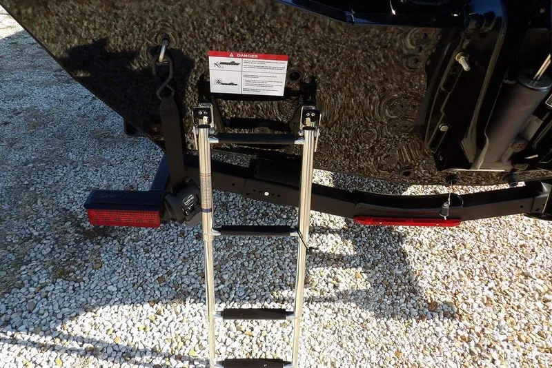 Slide: The Image of Rear view of 2026 Lund 1975 Renegade boat with ladder on gravel surface. - 46