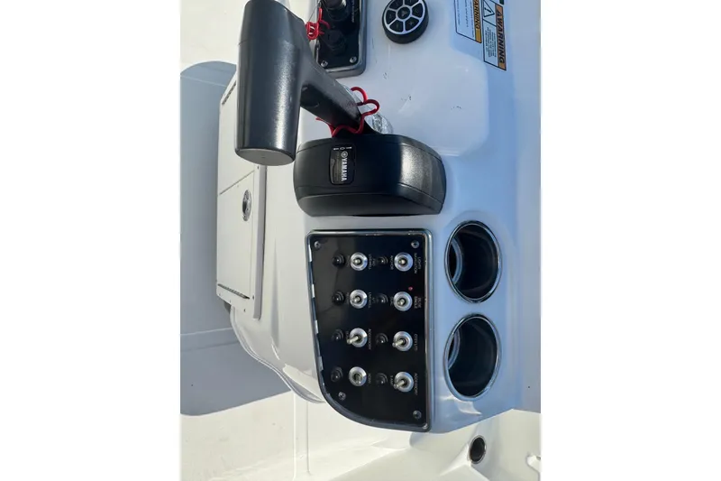 Slide: The Image of 2021 NauticStar 215 XTS Shallow Bay boat control panel with switches and throttle. - 18